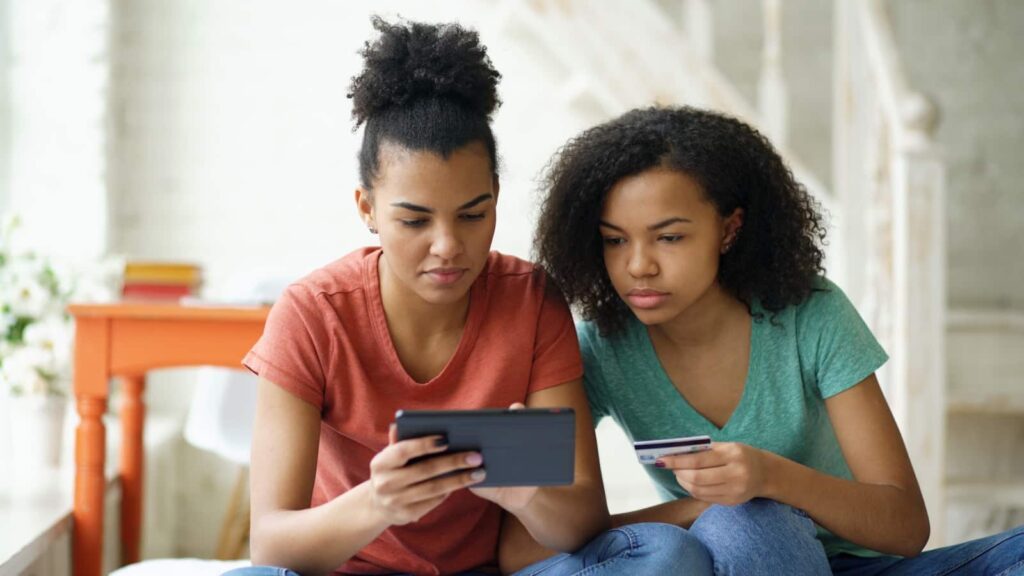 Two young women looking at a tablet device.