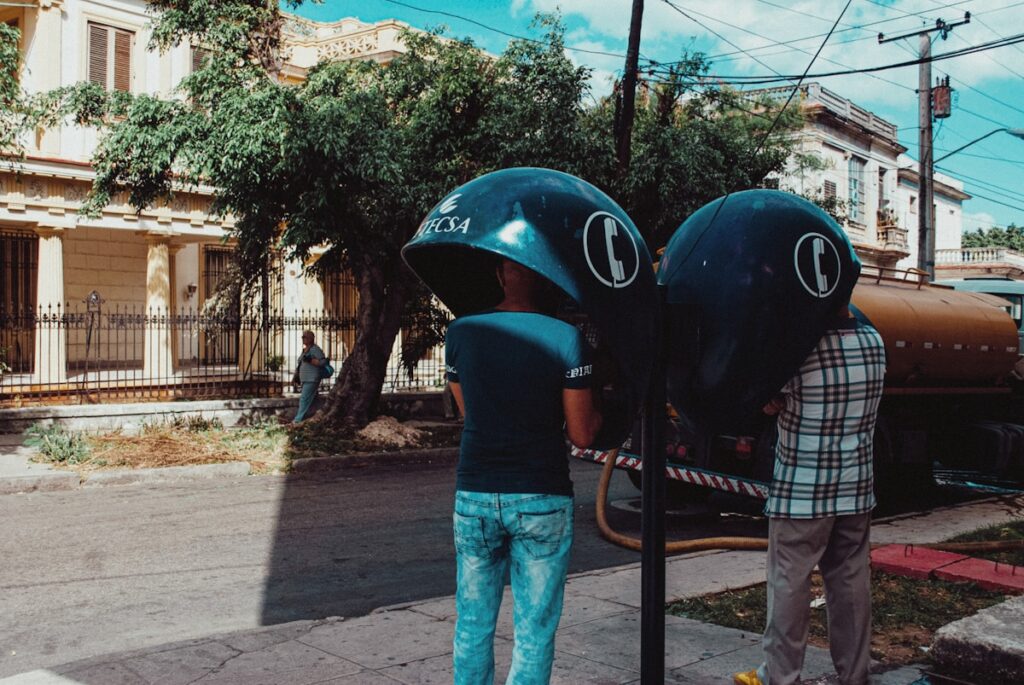 man in blue and white plaid shirt and blue denim jeans standing beside blue helmet